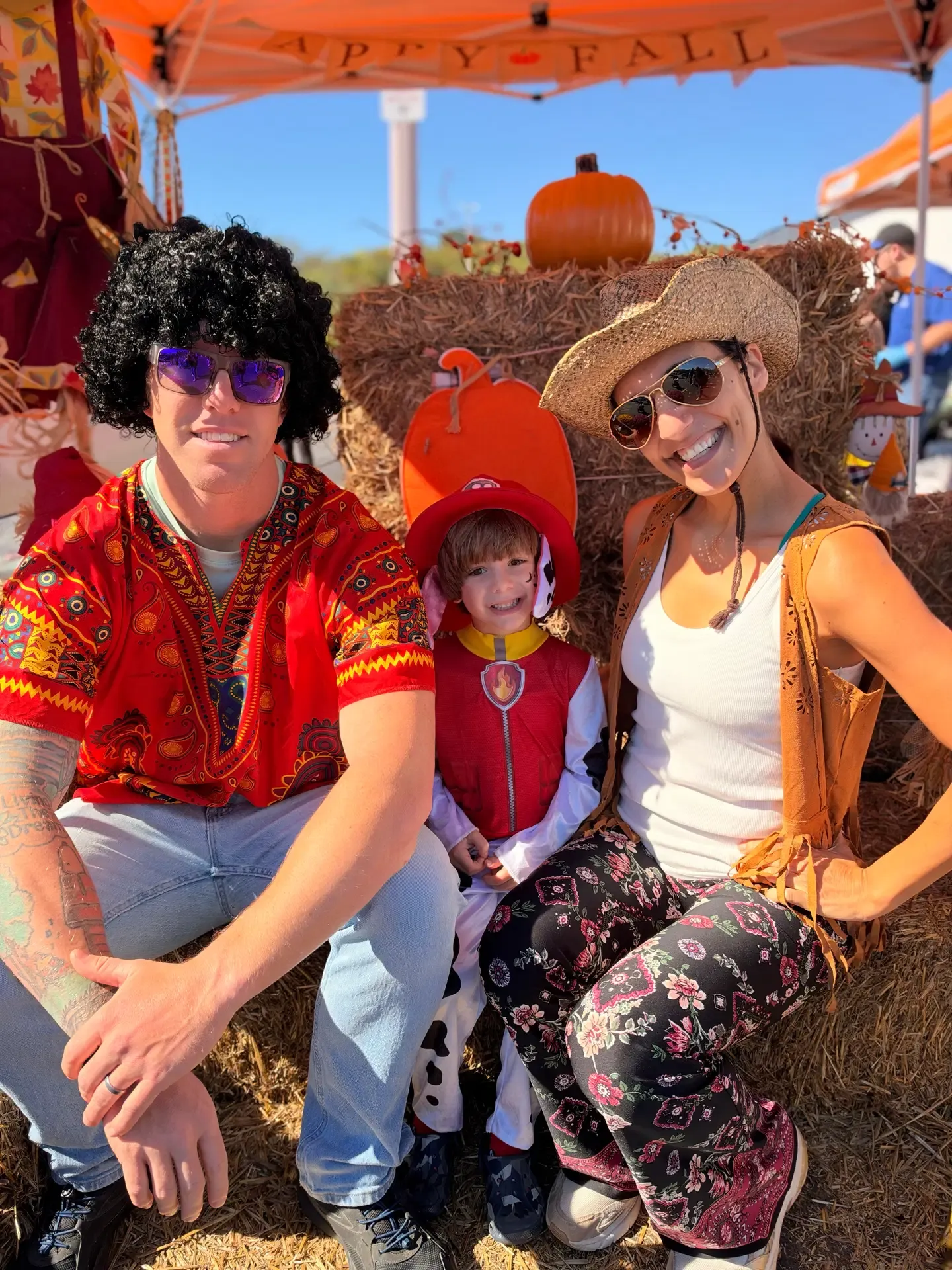 A family gathers around an autumn-themed festival display.