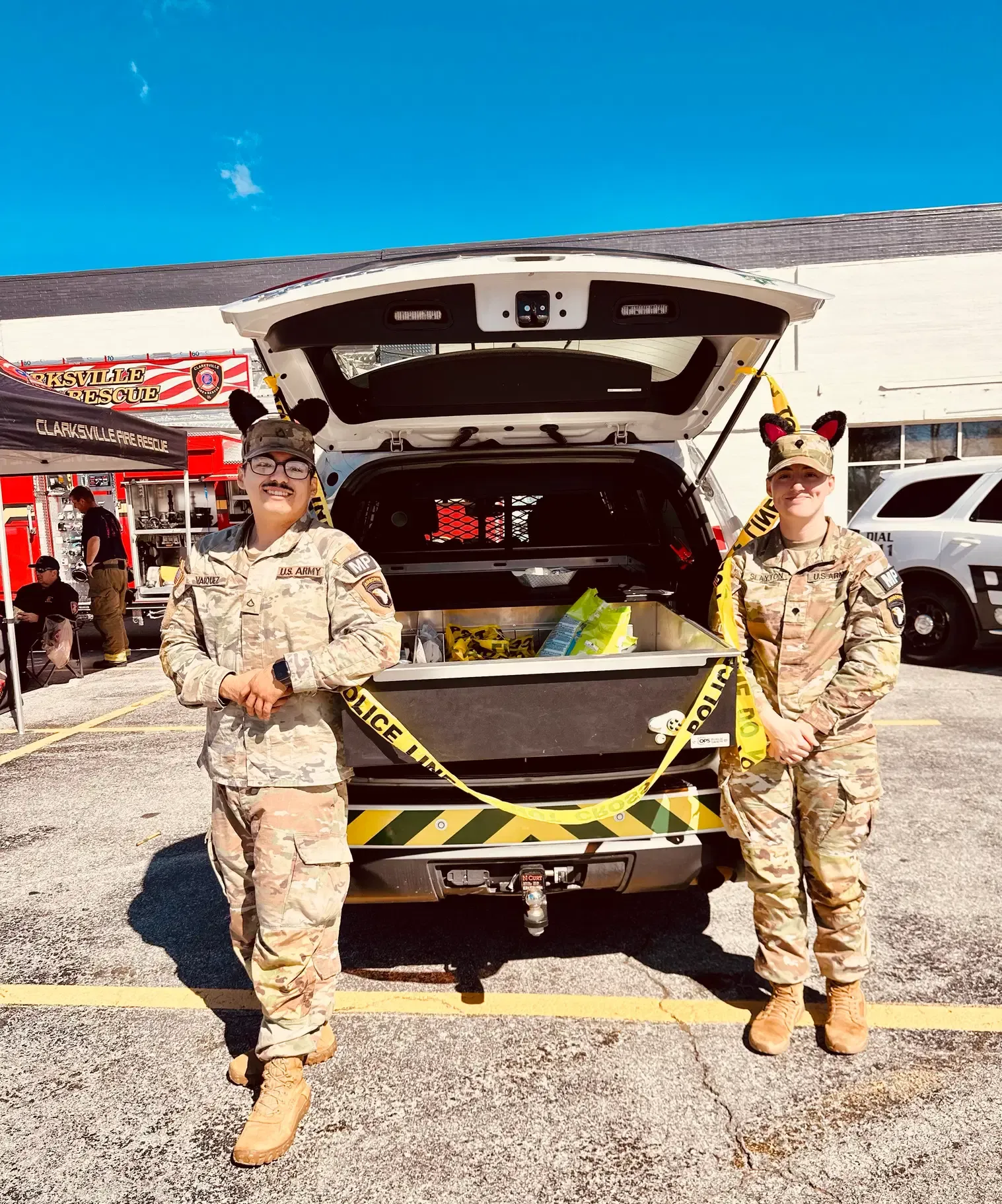 Two military police members pose beside a decorated vehicle.