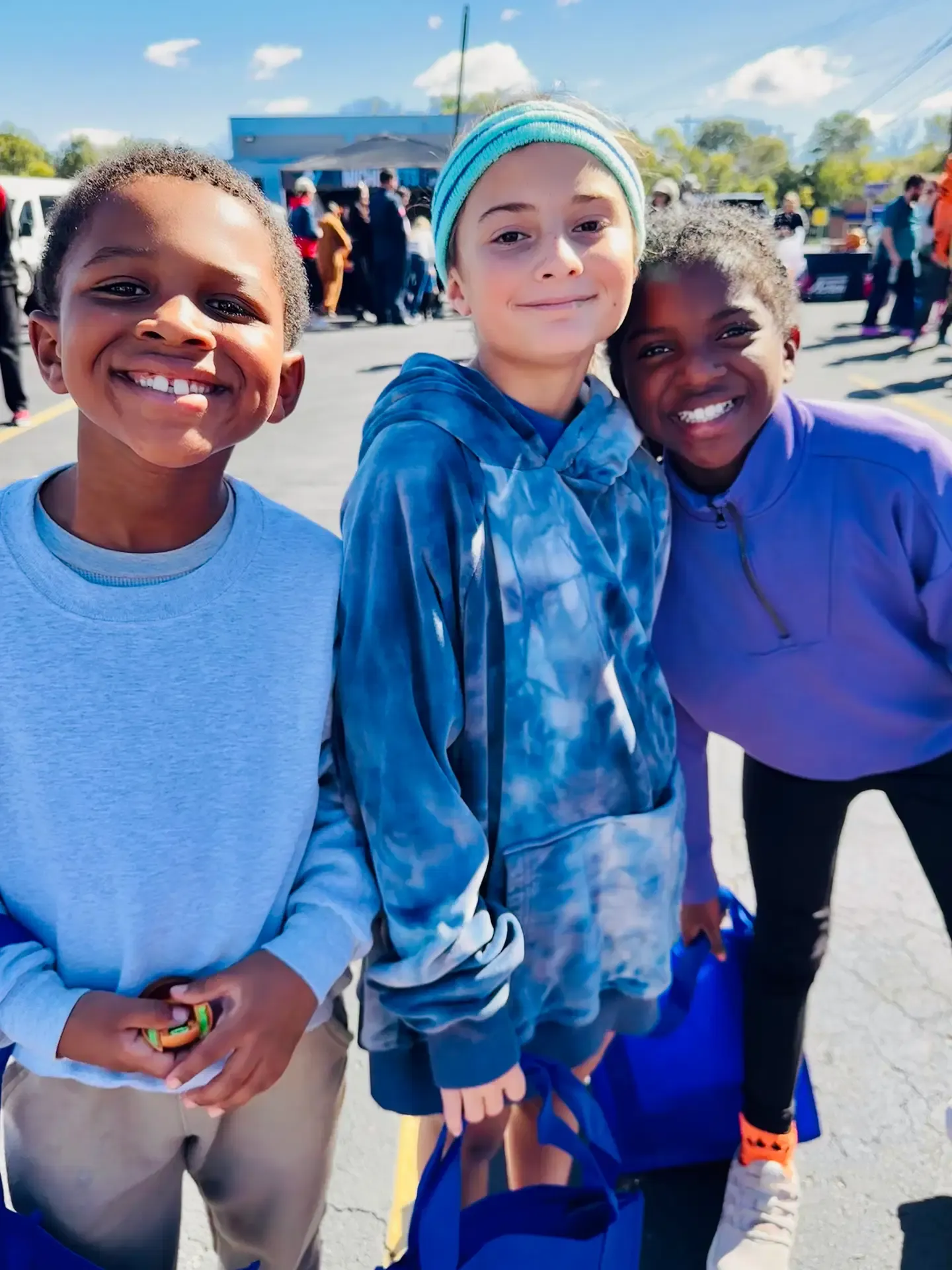 Three young festival guests smile together at the Fall Safety Festival.