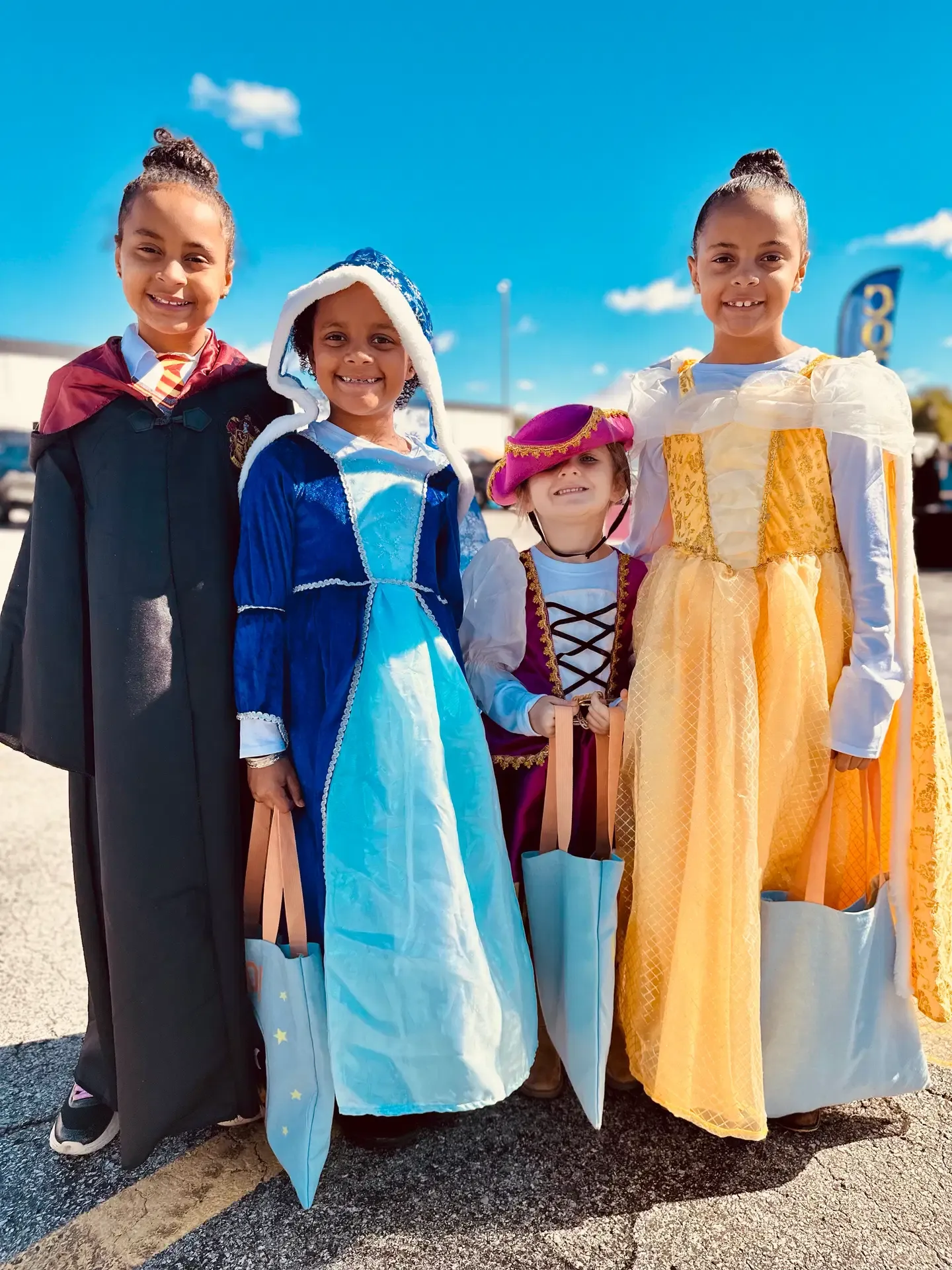 Three young festival guests in colorful storybook costumes pose together.