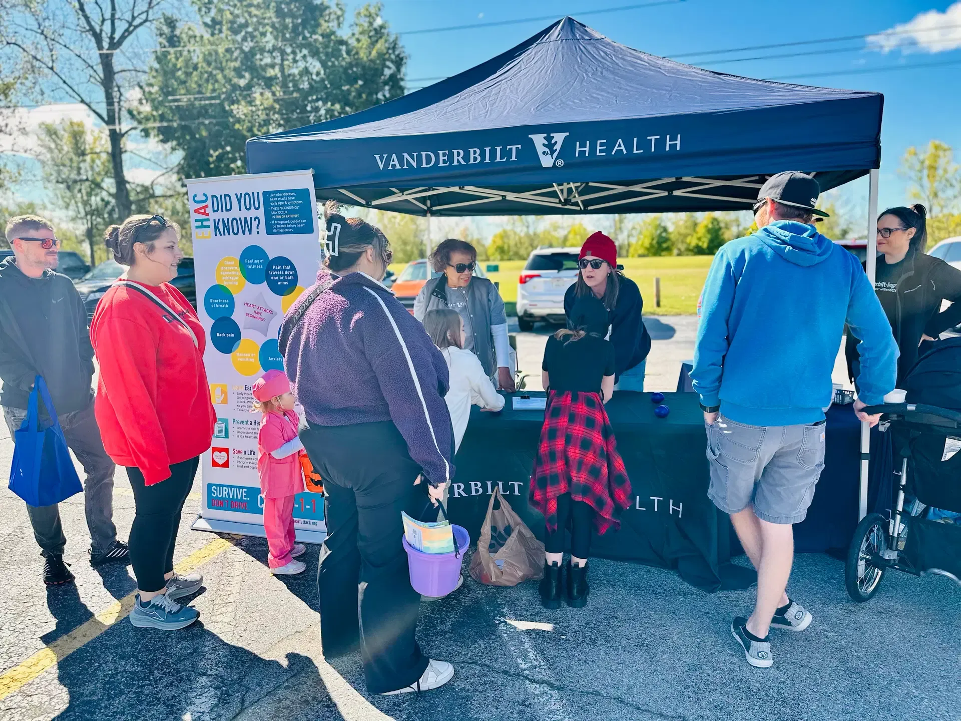 Visitors talk with Vanderbilt Health representatives beneath their community event tent.