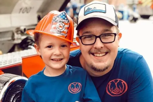 Justin Washvill with a young child at a community event